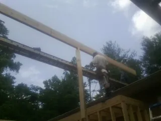 Carpenter setting a ridge beam over a new addition frame — Ice Dam Removal by Roofing Brothers in Joseph City