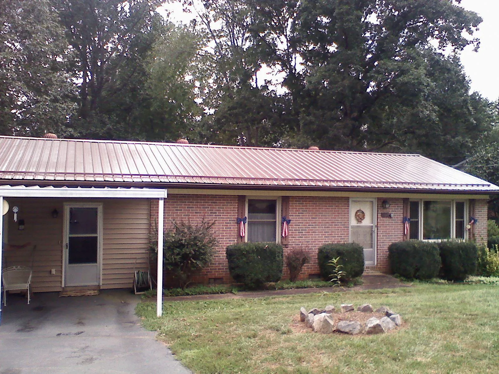 Bronze metal roof and carport on a brick ranch home — Roof Repair work by our crew in Joseph City
